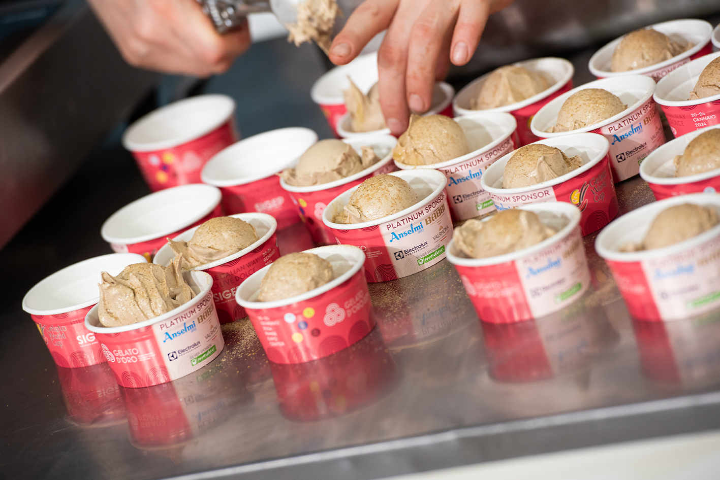 Svariate coppette ripiene di gustoso gelato pronte per essere servite ai giudici della Gelato World Cup 2024.